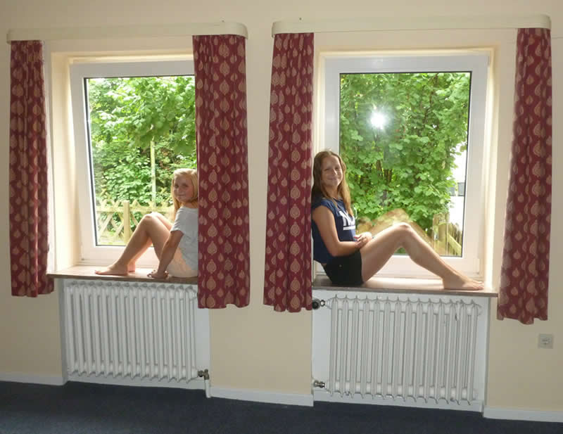 Our daughters sitting on window sill in empty house when move in to Germany